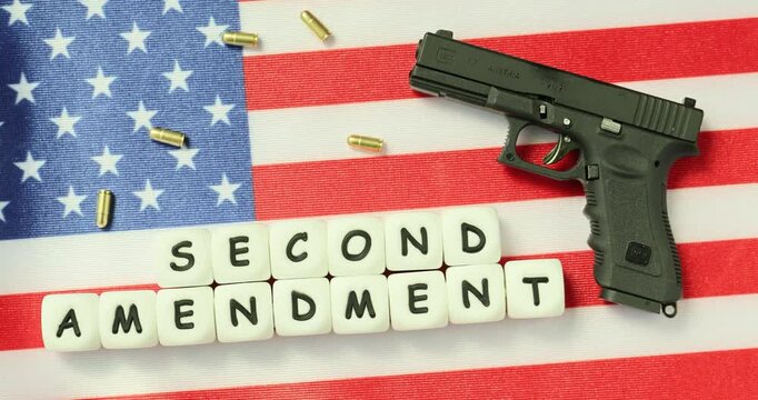 Cubes with words Second Amendment on American flag and gun nearby. Highlighting constitutional right to bear arms in United States