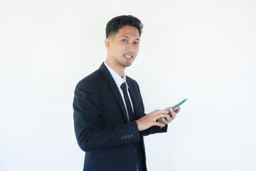 Asian businessman smiling while pointing to mobile phone that he hold