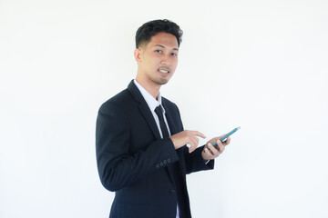 Asian businessman smiling while pointing to mobile phone that he hold