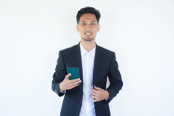 Asian businessman smiling confident at the camera and holding a mobile phone