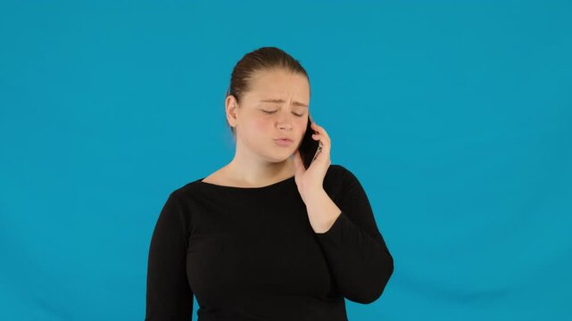 Young woman talks with authoritative tone on smartphone. Businesswoman eyes cool and voice carrying undercurrent of arrogance during conversation