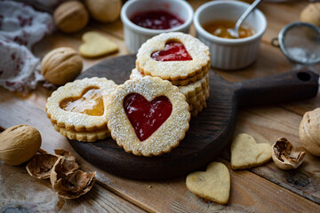 Sweet cookies with jam. Cookies in the shape of a heart on a wooden board. Sweet dessert for breakfast. Close-up
