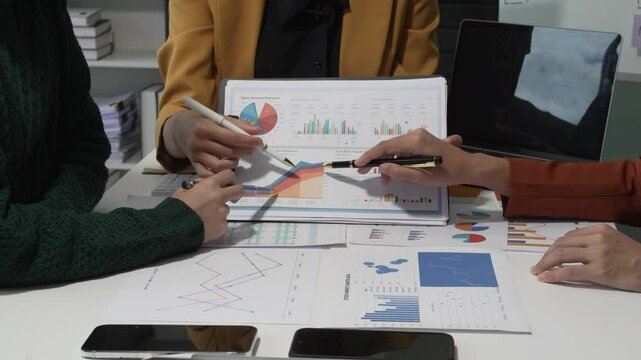 A group of people collaborates around a desk, discussing and reviewing user interface (UI) and user experience (UX) elements. usability, accessibility, and design principles for product development.