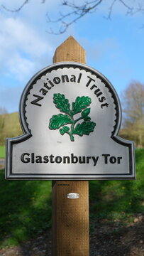 Sign post for National Trust Glastonbury Tor at the base of hill of popular tourist attraction in the Isle of Avalon, Somerset England on 30 March 2024