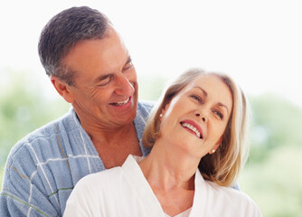 Obraz premium Mature couple, happy and hug outdoor on holiday for retirement, leisure and wellness with bonding. Man, woman and anniversary celebration at hotel with smile on vacation for peace, health and love
