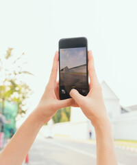 Woman traveler taking photo on camera at temple or palace wall. summer tourism concept.