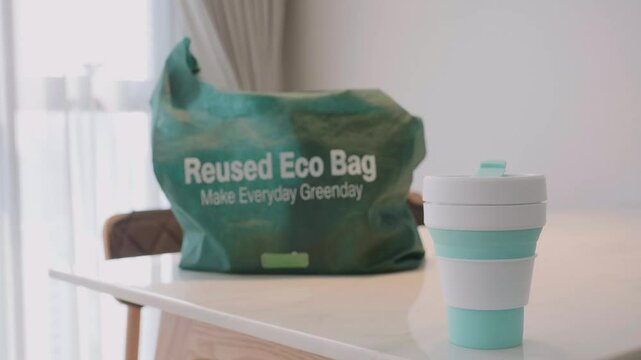 A green bag that says Reused Eco Bag on it
