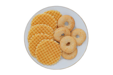 Variety of cakes and waffles in ceramic plate isolated on a white background. Yellow romantic biscuit. Top view.