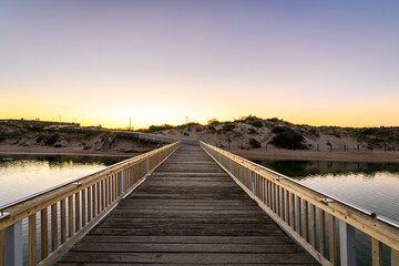 Fototapeta premium Southport boardwalk towards the surf life saving club across the Onkaparinga river at sunset