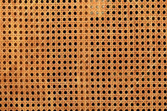 Orange ratten mesh as a background. Texture of ratten mesh with holes