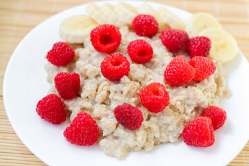 Oatmeal with pieces of raspberry and banana
