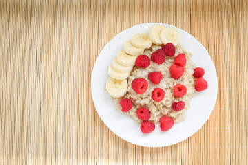 Oatmeal with pieces of raspberry and banana
