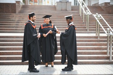 Group of multiracial graduate students with diplomas on university background