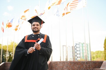 Portrait of happy man, graduation or student in university campus