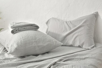 gray pillow and natural linen bed sheet