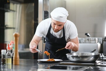 Gourmet chef in uniform cooking in a commercial kitchen