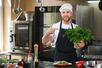 Chef cook in uniform cooking in the big cooker at the restaurant kitchen