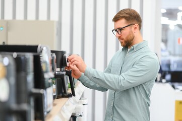 Man choosing crockpot at electric store