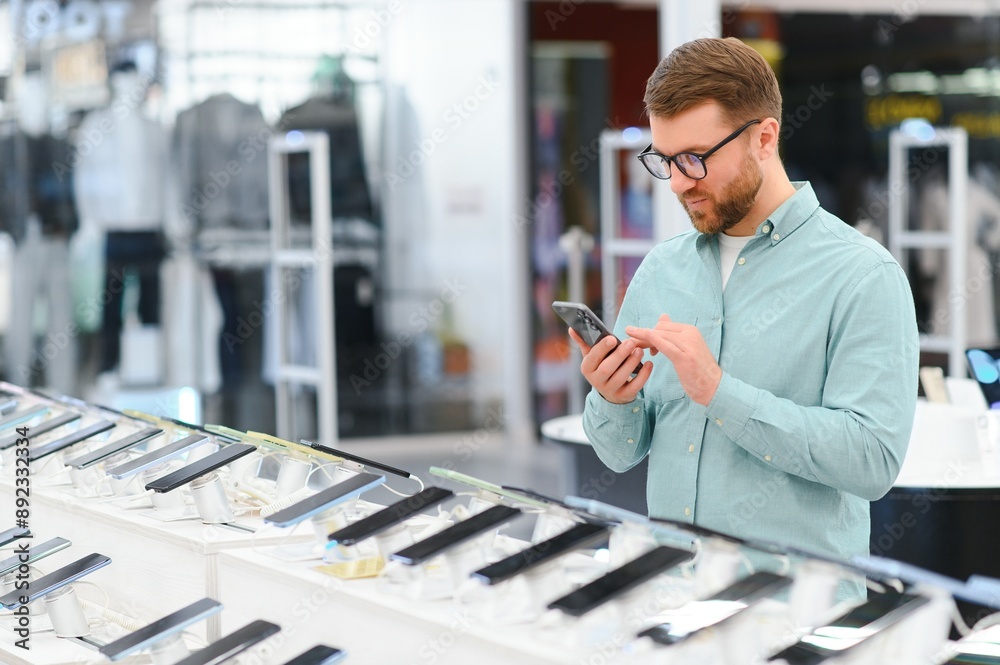 Wall mural guy in an electronics store chooses a cell phone to buy