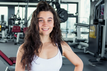 Fototapeta premium Girl is training for sport in gym. fit athlete exercise concept. girl is doing workout in a gym. a girl is doing a workout in a gym lifestyle while doing some sport.