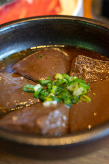 A hearty serving of duck blood tofu sits in a steaming hotpot, enriched with flavorful broth and a medley of spices. This authentic Asian delicacy boasts a silky texture and rich, savory taste