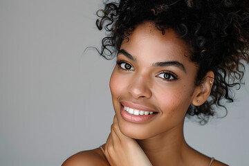 Beautiful woman with curly hair looking in the camera against light background