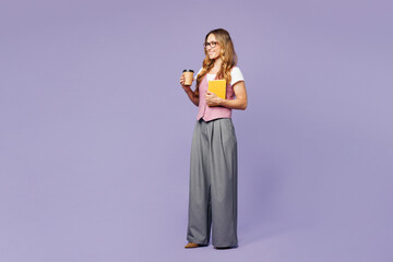 Full body side view young employee business woman corporate lawyer wearing suit vest white t-shirt glasses work in office hold book notebook hold cup drink coffee isolated on plain purple background.