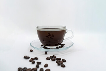 Espresso Americano in a glass cup with fresh coffee beans scattered around Isolated White Background