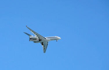 Private jet against the blue sky as it approaches Nice, France