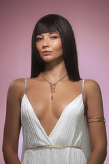 Confident Woman With Sleek Black Hair in White Dress and Gold Accents