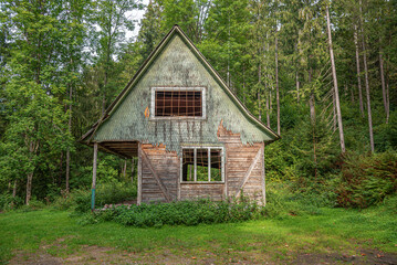 Old wooden abandoned house in the forest.