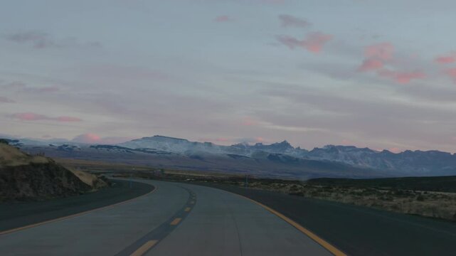 a sunrise pov shot driving towards torres del paine national park with cerro pinaculo peak in the distance