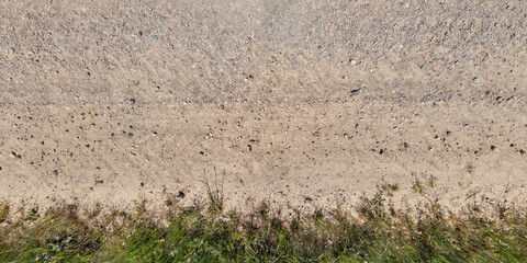 view from above on texture of dry muddy road with tractor tire tracks in countryside