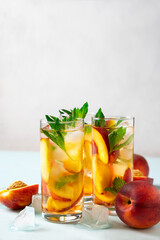 Cocktail or mocktail in glass and fruit peach half and whole