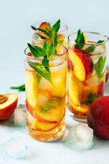 Cocktail or mocktail in glass and fruit peach half and whole