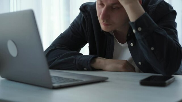Shocked frustrated European businessman student feeling stressed looking at computer screen worried about problem reading bad online news getting failed exam results