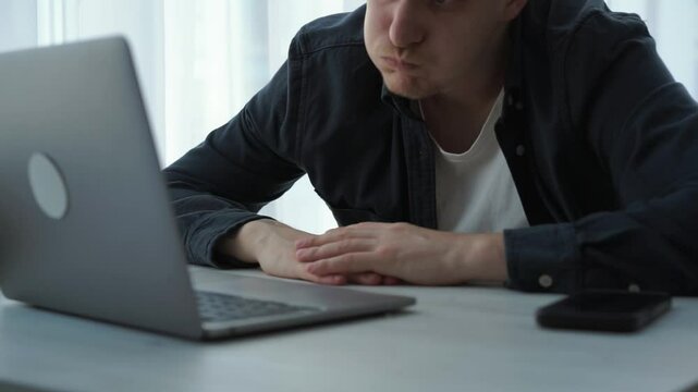 Tired European freelance businessman working from home suffers from headache. Sick, exhausted, European man, student, guy, tired from working on a laptop, pain in the head, health problems