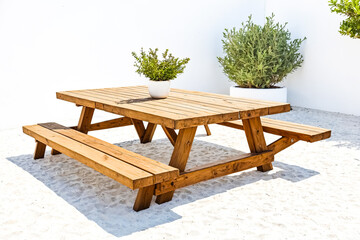 Wooden picnic table on white sand beach