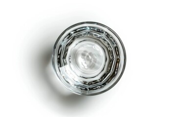 A clear glass filled with water sits on a smooth white surface