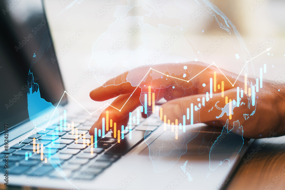 Poster fingers typing on a laptop keyboard with a financial chart overlay.