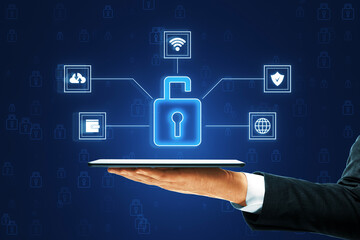 Hand holding tablet with holographic cybersecurity icons on blue background.