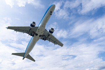 Landing airplane on the background of blue sky.