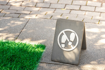 A sign on the ground that says no shoes