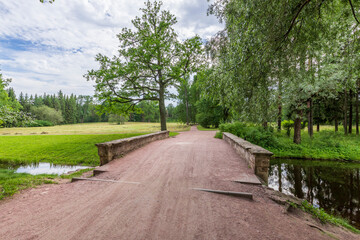 A path in a park with a bridge over a creek