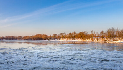 Fototapeta premium A frozen lake with trees in the background