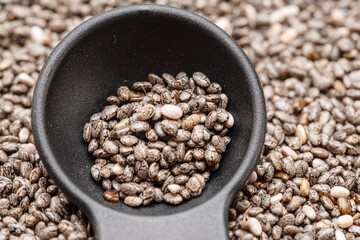 Spoon of chia seeds over chia seeds. Food background.