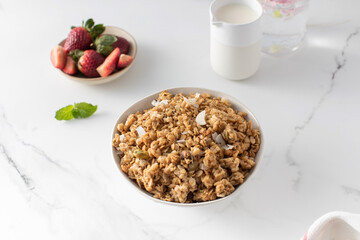 Crispy homemade granola with sliced almonds in a bowl with strawberries. Healthy eating