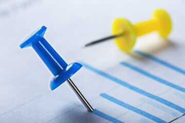 Marking financial chart by pins.Share listing and checking financial chart. Concept of banking, financial report and financial audit.
