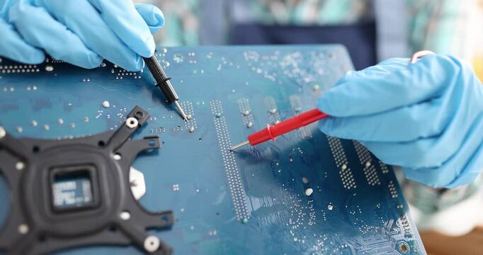 Chip repairman testing circuit and electronics technician is testing computer chip. PC repair