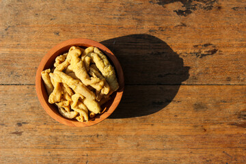 Fried chicken intestines Indonesian food is called usus goreng in a small wooden bowl with wooden background
